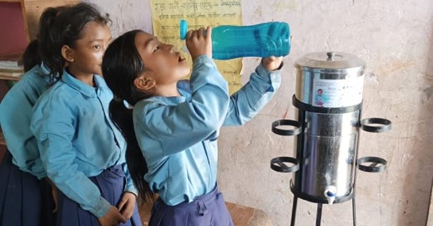 Ein Mädchen trinkt sauberes Wasser aus einer Flasche. Das Wasser wird von einer Anlage von ECCA produziert und wurde durch Spenden aus der Impact Anteilsklasse des Tareno Global Water Solutions Fund finanziert.