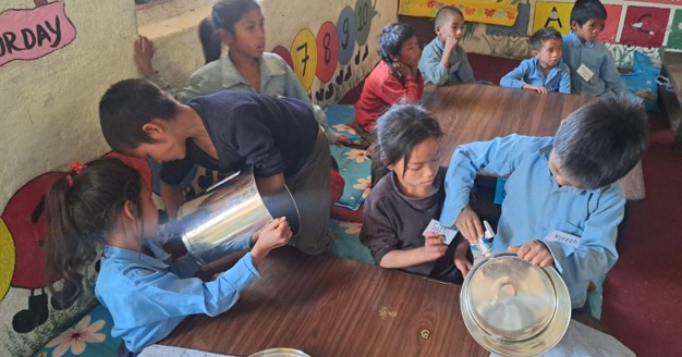 Verschiedene Kinder sind zu sehen, die sauberes Trinkwasser aus Kanistern entnehmen. Das Wasser wird von einer Anlage von ECCA produziert und wurde durch Spenden aus der Impact Anteilsklasse des Tareno Global Water Solutions Fund finanziert.